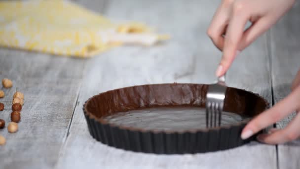 フォークで全体にわたって菓子ケースのベースを刺します チョコレートのタルトを作る — ストック動画