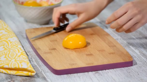 Вырезать консервированный персик на деревянной доске . — стоковое видео