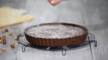 Masanın üzerinde bir plaka üzerinde fındık ile çikolatalı tart