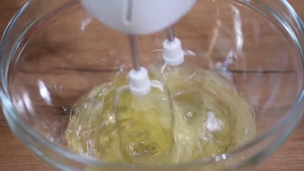 Sbattere le proteine dell'uovo nella ciotola di vetro. Processo di frusta di proteine con miscelatore elettrico in ciotola di miscelazione . — Video Stock