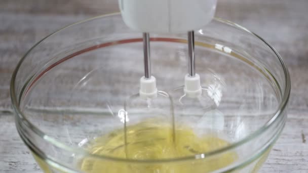 Sbattere le proteine dell'uovo nella ciotola di vetro. Processo di frusta di proteine con miscelatore elettrico in ciotola di miscelazione . — Video Stock