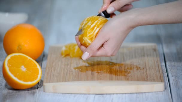 Laranja descascada na placa de corte de madeira . — Vídeo de Stock