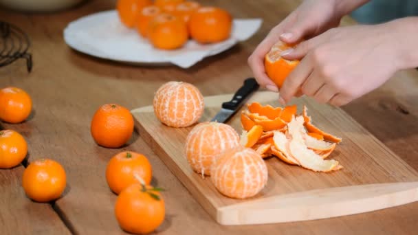 Ženská ruka loupání zralé sladké mandarinky, zblízka. — Stock video