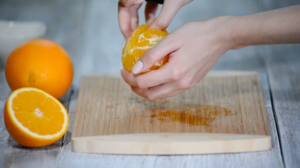 Naranja pelado sobre tabla de cortar de madera . — Vídeos de Stock