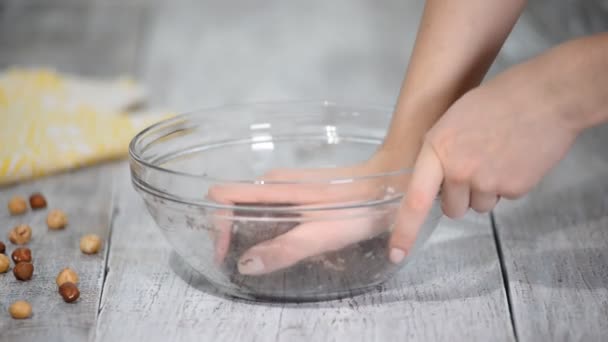 Le mani femminili impastano la pasta marrone di cioccolato per biscotti. Il concetto di cucina . — Video Stock