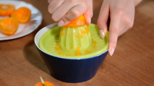 La mano femenina exprime el jugo de mandarinas . — Vídeo de stock
