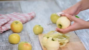 Yemek elma bir ahşap tahta üzerinde peeling eller.