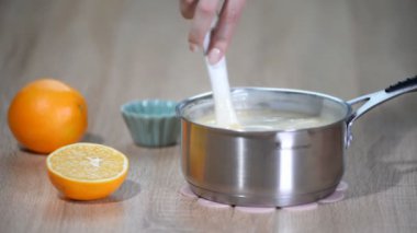 Kadın el tencerede muhallebi karıştırın.