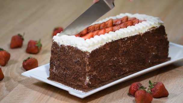Kvinnlig hand skära tårtan med vispad grädde och jordgubbar frukter. — Stockvideo