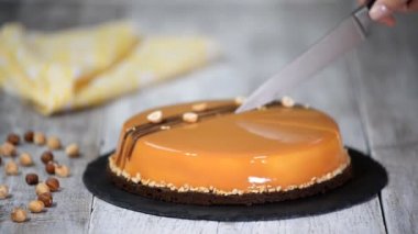 Karamelli mus kek kesme el. Karamel pasta, mus tatlı bir plaka üzerinde.