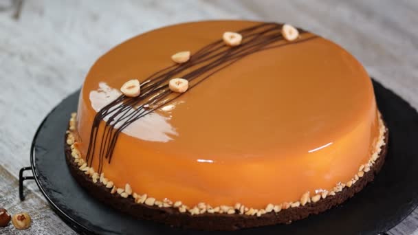 Versieren van de taart caramel mousse met een bladgoud. — Stockvideo