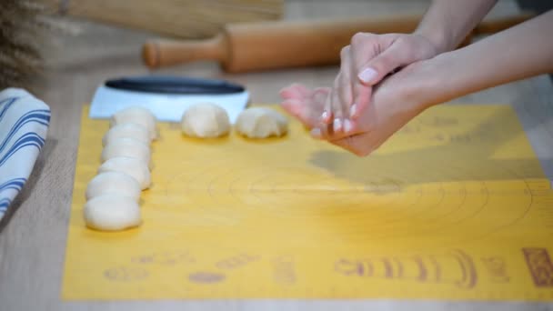 Les mains de la femme roulent la pâte à pain. Filles mains pétrissant la pâte dans la farine sur la table . — Video