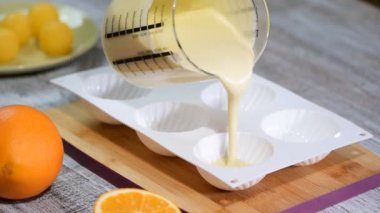 Pasta şefi ile sıvı köpük silikon kalıp doldurma. Pasta silikon kalıba dökme yakın çekim. Şekerleme imalatında tatlılar.