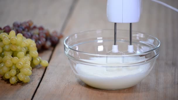 Crème fouettée dans un bol en verre avec des fouets . — Video