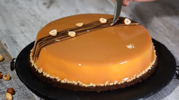 Decora el pastel de mousse de caramelo con una hoja de oro . — Vídeos de Stock