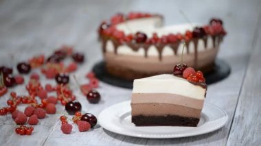 Üç çikolatalı mousse kek dilimi küçük bir plaka üzerinde