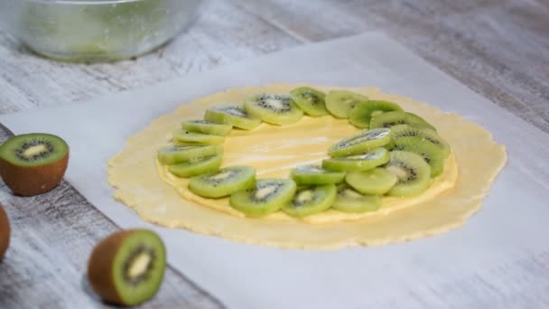 Manos femeninas haciendo galette con kiwi fresco . — Vídeos de Stock