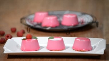 Üç güzel mus kek ayna parlak sır ile kaplı. Lezzetli dessserts yaratma süreci.