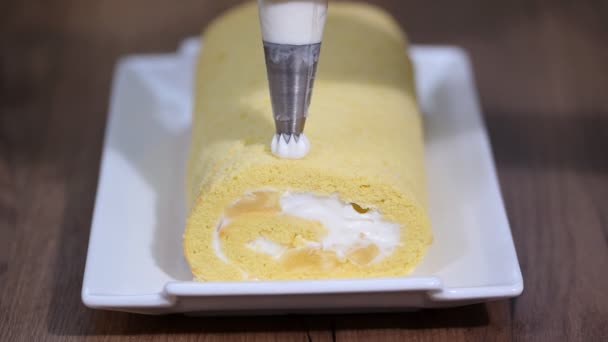 Decora el rollo de esponja dulce con una crema . — Vídeos de Stock