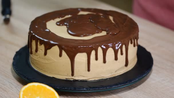 Koch drückt Sahne. Schokolade als Sahnehäubchen. Schokoladenkuchen-Dekoration.