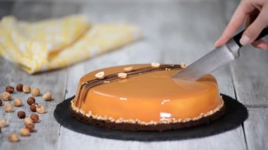 Karamelli mus kek kesme el. Karamel pasta, mus tatlı bir plaka üzerinde. Mousse kek bir ayna sır ile