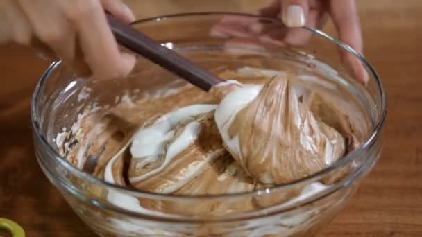 Womans hands mix cream and chocolate for cake preparation. — Stock Video