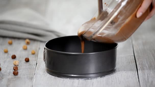 Pouring chocolate batter into pan. Woman in the kitchen making chocolate cake. — Stock Video