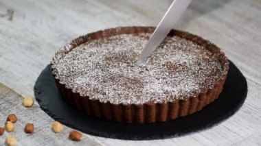 Rustik arka plan üzerinde kesme ev yapımı koyu çikolata tart.