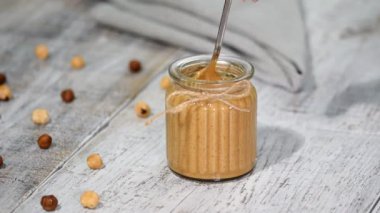 Ev yapımı fındık yapıştırın pralin bir kavanoz içinde.