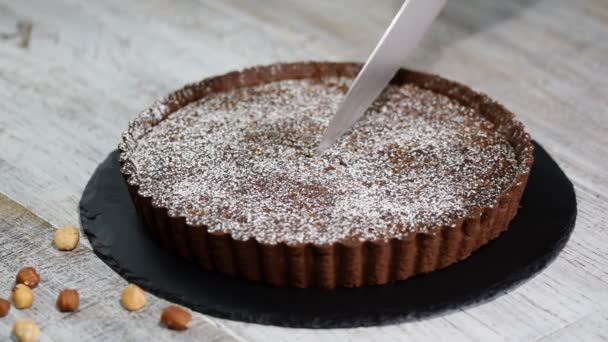 Snijden zelfgemaakte donkere chocolade taart op rustieke achtergrond. — Stockvideo