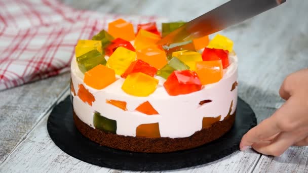 Разрезание торта с красочными фруктовыми кусочками желе . — стоковое видео