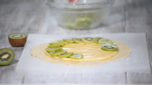 Female hands making galette with fresh kiwi. — Stock Video