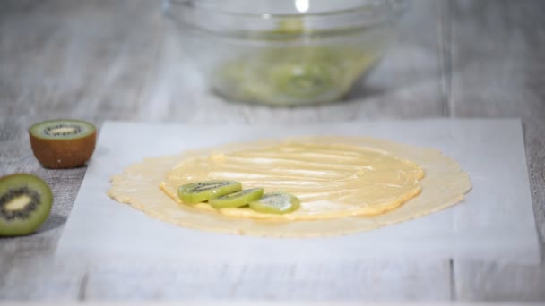 Female hands making galette with fresh kiwi. — Stock Video