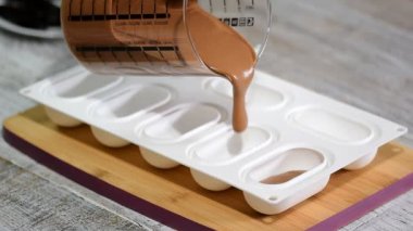 Bir silikon kalıp çikolata mousse ile doldurma eller yakın çekim. Fransız tatlı yapma.