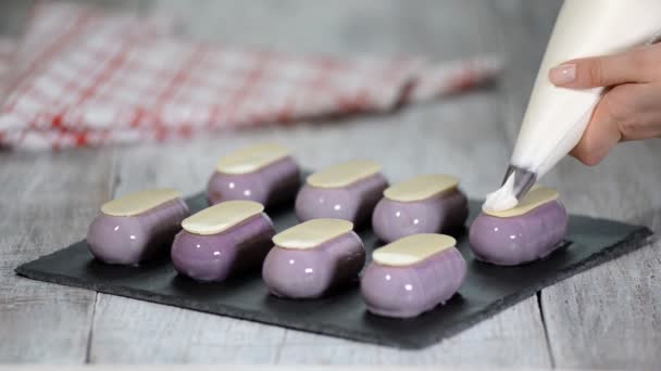 Pastelería decorar pequeños pasteles con crema batida en la cocina . — Vídeos de Stock