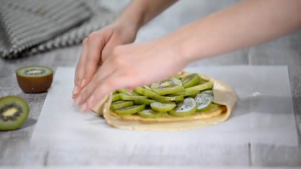 Ženské ruce galette s čerstvým kiwi. — Stock video