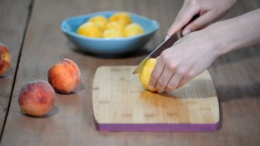 Eller üzerinde piknik salata için ahşap bir gemide şeftali parçalar koparıp.