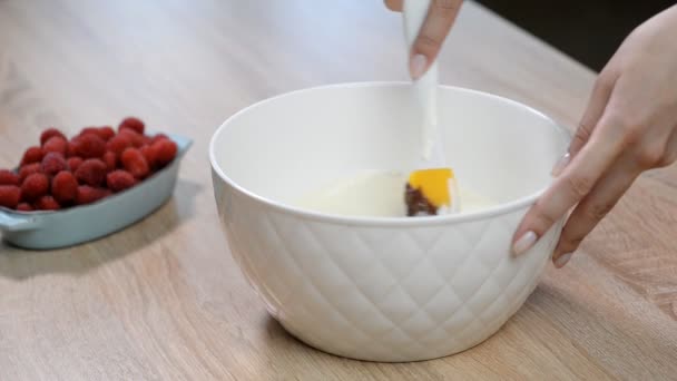 Mexendo creme de leite com pedaços de chocolate em uma tigela . — Vídeo de Stock