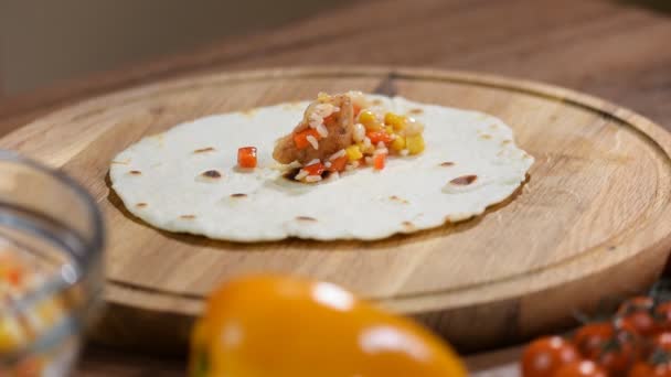 La mano de mujer está haciendo burrito casero de comida tradicional mexicana, fajitas, quesadillas, enchiladas o tacos con queso cheddar . — Vídeo de stock