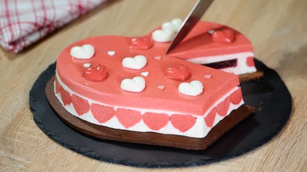 Taart in de vorm van hart voor Valentijn vakantie. Snijden stuk van mousse taart. — Stockvideo