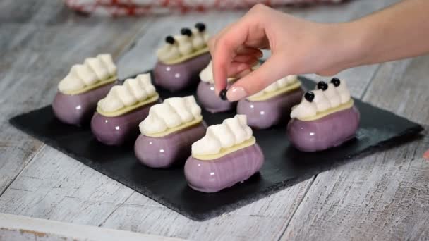 Confectioner decorates mousse cake with a blueberries Production of glazed desserts. — Stock Video