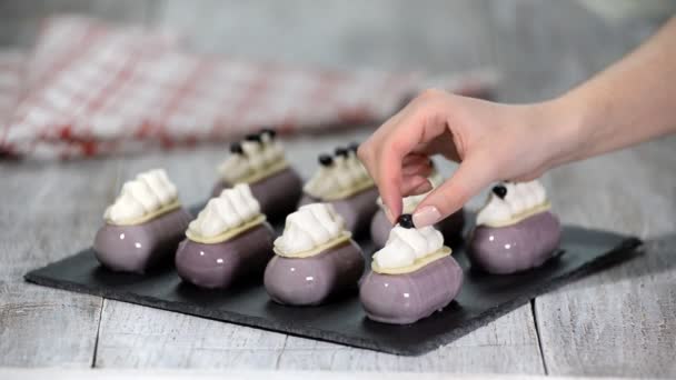 Confectioner decorates mousse cake with a blueberries Production of glazed desserts. — Stock Video