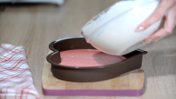 Verser de la mousse de vanille dans des moules en forme de cœur. Confiseur faisant gâteau mousse dans la cuisine . — Video
