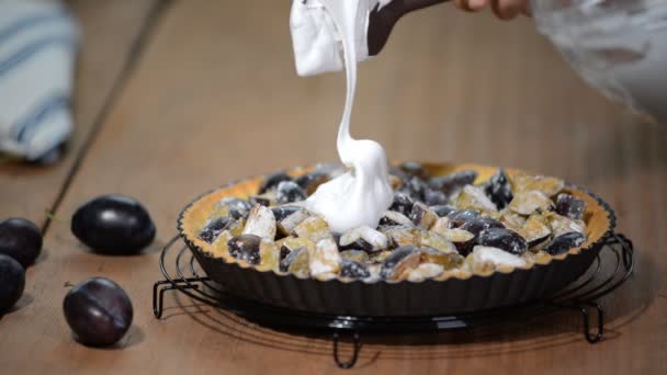 Mujer en la cocina haciendo tarta con ciruelas y merengue. Tarta de ciruela casera, postre de otoño con ciruelas frescas . — Vídeos de Stock