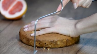 Kadın pasta şefi masada bir pasta dilimleme.