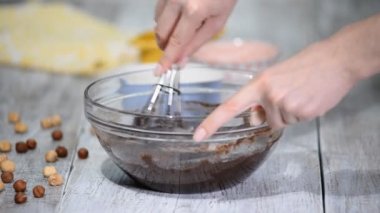 Kek için çikolatalı hamur yapma - kakao hamuru karışımı karıştırma. Fındık için meyilli ekleyin