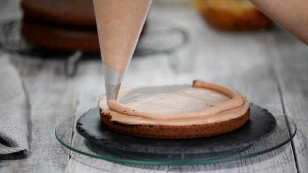 O confeiteiro fazendo bolo de chocolate com amendoim de caramelo. Passo a passo montagem ceke chocolate — Vídeo de Stock