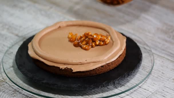 El confitero que hace la torta de chocolate con los cacahuetes de caramelo. Paso a paso montaje ceke chocolate . — Vídeos de Stock