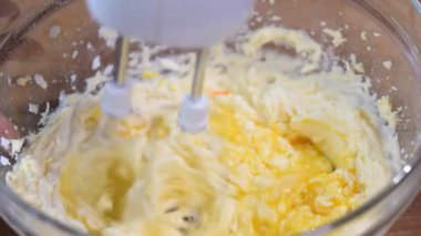 Kek hamuru closeup bir elektrikli karıştırıcı ile karıştırma.
