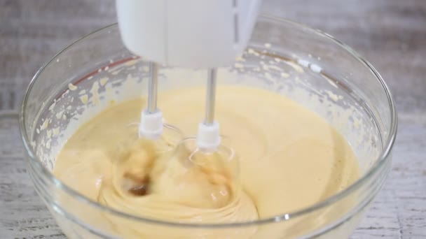 Mikser kuchenny zbliżenie bije składniki na ciasto w misce szkła. — Wideo stockowe
